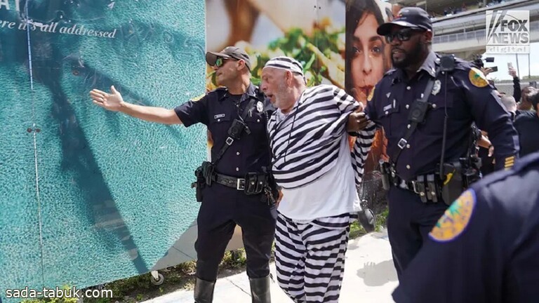 بالفيديو .. محتج بملابس سجين يلقي بنفسه أمام سيارة ترامب في ميامي